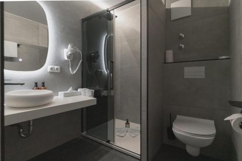 a bathroom with a shower and a sink and a toilet at Hotel Andante Rust in Rust