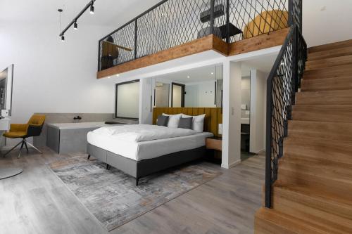 ein Schlafzimmer mit einem großen Bett und einer Treppe in der Unterkunft Hotel Andante Rust in Rust