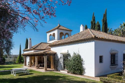 ein weißes Gebäude mit einem Turm darauf in der Unterkunft Hacienda el Burgo in Mairena del Aljarafe
