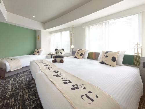 a bedroom with two beds with a teddy bear sitting on them at Mitsui Garden Hotel Ueno - Tokyo Reopened in July 2023 in Tokyo