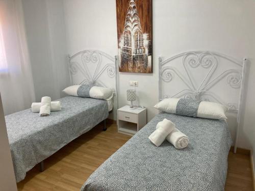 1 dormitorio con 2 camas y almohadas blancas en Apartamento Casco Antiguo, en Linares