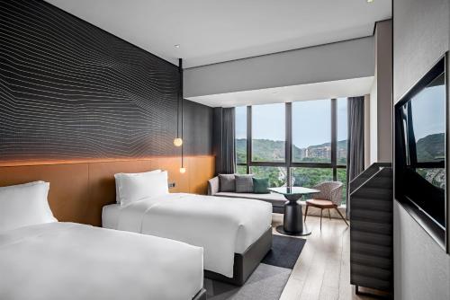 Postel nebo postele na pokoji v ubytování The G Shenzhen, A Tribute Portfolio Hotel