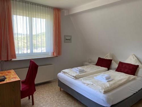 a bedroom with two beds and a table and a window at Haus Adams - das Wohlfühl Gästehaus in Boppard