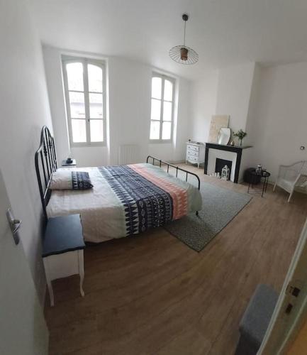 a bedroom with a bed in a white room at Maison de ville familiale in Caussade