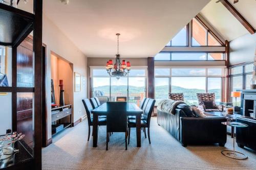 a dining room and living room with a table and chairs at Luxurious Altitude Ski-in/Ski-out in Mont-Tremblant