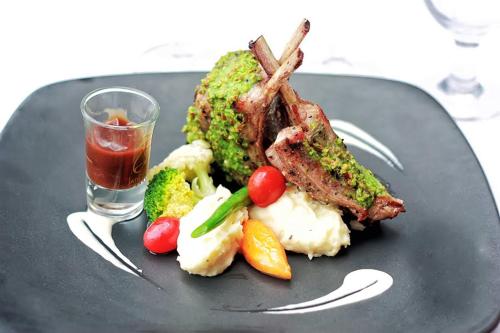 a plate of food with meat and vegetables and a drink at Grand Jatra Hotel Pekanbaru in Pekanbaru