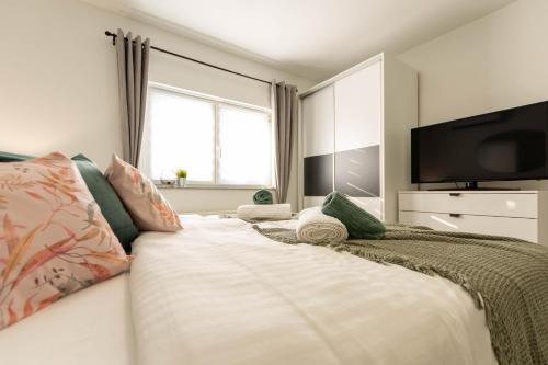 a bedroom with a large bed with a flat screen tv at apartmani SUN & MOON in Bjelovar