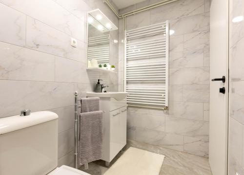 a white bathroom with a toilet and a sink at apartmani SUN & MOON in Bjelovar