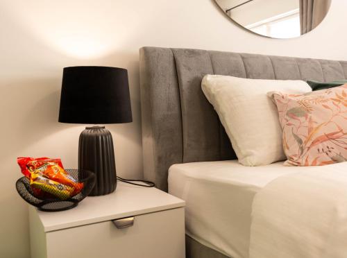 a lamp on a night stand next to a bed at apartmani SUN & MOON in Bjelovar