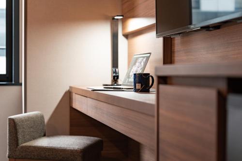 a room with a desk with a chair and a mug at The Royal Park Canvas - Kobe Sannomiya in Kobe