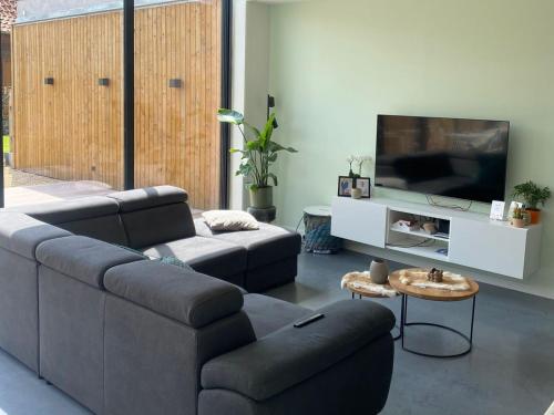 a living room with a couch and a flat screen tv at Maison Beau in Veurne