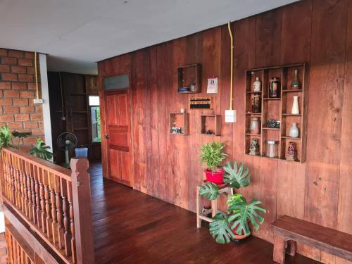 a hallway with wooden walls with plants and shelves at Ha Me Garden ฮามีการ์เด้น โฮมสเตย์ฝาง in Fang