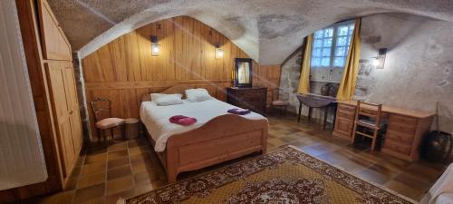 a bedroom with a bed and a desk and a window at Maison au Loup - Superbe ancien hotel particulier du XVIe siècle au cœur de la vieille ville du Puy in Le Puy-en-Velay