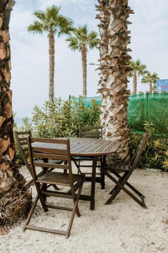 a wooden picnic table and a bench next to palm trees at Villa Bahari by Seaward Suites in Villajoyosa