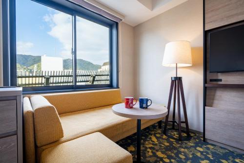 a hotel room with a couch and a large window at The Royal Park Canvas - Kobe Sannomiya in Kobe
