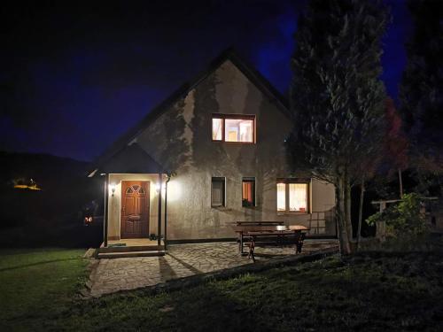 une maison avec une porte et un banc devant elle dans l'établissement Domek w Grabówce, 