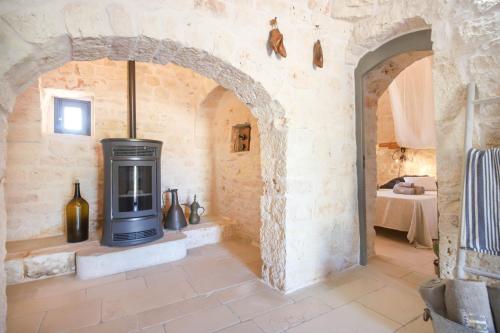 a stone room with a wood stove in it at TD Trulli Albapetra Pool Olive Trees in Polignano a Mare