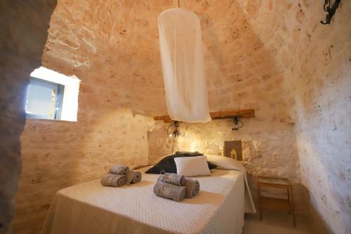 a bedroom with two beds in a stone wall at TD Trulli Albapetra Pool Olive Trees in Polignano a Mare