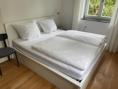 a bed with white sheets and pillows in a bedroom at ZwergDackelAdlerHirsch in Beuron