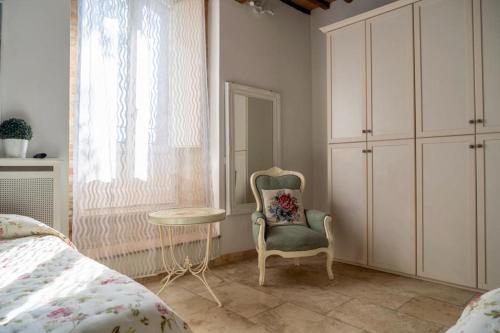 a bedroom with a bed and a chair and a table at Agriturismo Percenna in Buonconvento