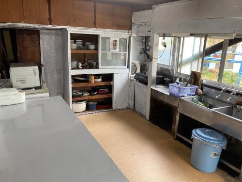 a kitchen with a sink and a counter top at 素泊まり民宿とみや in Oshima