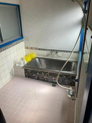 a bathroom with a sink and a bath tub at 素泊まり民宿とみや in Oshima