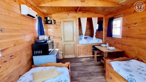 a room with two beds in a log cabin at Roulotte et Jacuzzi de Rachel au Domaine du Reuze in Winnezeele