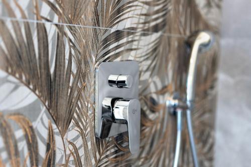 a metal switch on a wall in a bathroom at Mansarda Vialba in Germignaga
