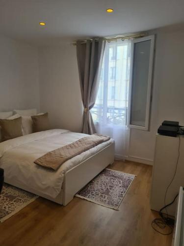 une chambre avec un grand lit et une fenêtre dans l'établissement Très beau studio au pied du métro, à Vincennes