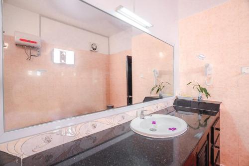 a bathroom with a sink and a large mirror at Ravoeun Angkor Boutique in Siem Reap