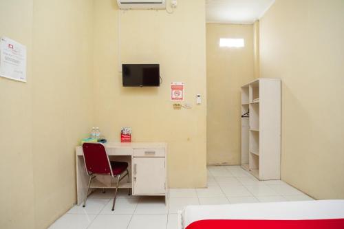 a hospital room with a desk and a red chair at RedDoorz near Universitas Muhammadiyah Pringsewu in Margakaya
