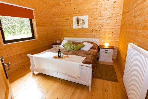 a bedroom with a bed in a wooden cabin at 5 Sterne Ferienhaus Tommy mit Kamin, Seeblick und großer Terrasse in Rieden
