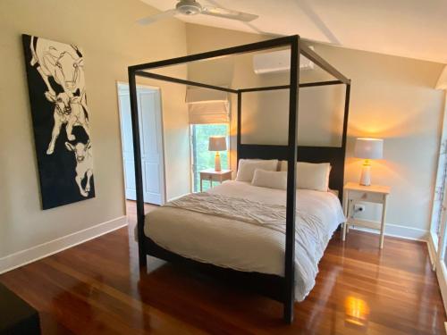 Un dormitorio con una cama con dosel en una habitación en Dungog Farmstay - Kingaley, 