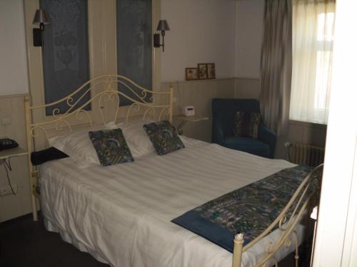 1 dormitorio con 1 cama blanca y 1 silla azul en Maisondelavallee, en Bièvre
