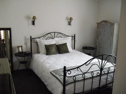 1 dormitorio con 1 cama con sábanas y almohadas blancas en Hôtel de la vallee, en Bièvre