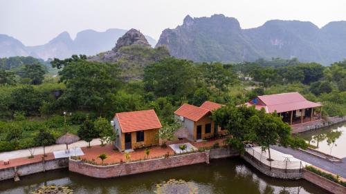 une vue aérienne de deux maisons dans l'eau avec des montagnes en arrière-plan dans l'établissement Tam Coc Cat Luong Homestay, à Ninh Binh