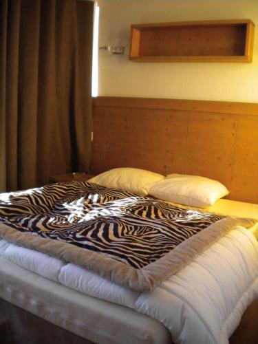 a zebra blanket on a bed in a room at Lagrange Vacances Le Roc Belle Face in Arc 1600
