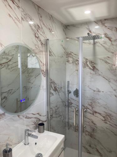 a bathroom with a shower and a sink and a mirror at Studio La Cigale bord de mer in Menton