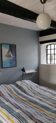a bedroom with a bed with a colorful striped bedspread at Fuglsanggaard Stalden in Præstø