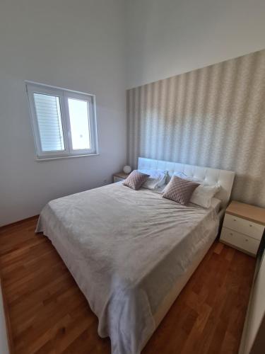 a bedroom with a large bed and a window at Apartment Diana in Rogoznica