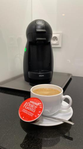 a cup of coffee sitting on a counter next to a coffee maker at apartament LeśnaCedzyna in Cedzyna