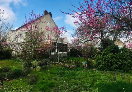 a garden with pink flowers in front of a building at La Ptite Fabrique chez Malot in Montceau-les-Mines