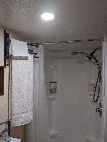 a bathroom with a shower and white towels at Country Cottage in Papa Bay in Papa Bay Estates