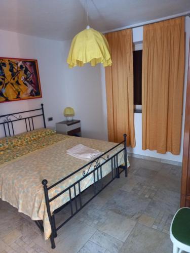 1 dormitorio con 1 cama y un colgante amarillo en Ca' d Licio, en Polinago