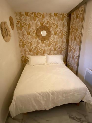 Ce lit se trouve dans une petite chambre dotée d'un mur. dans l'établissement Cap Raphaël, à Saint-Raphaël