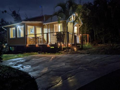 uma pequena casa com luzes à frente à noite em Country Cottage in Papa Bay em Papa Bay Estates