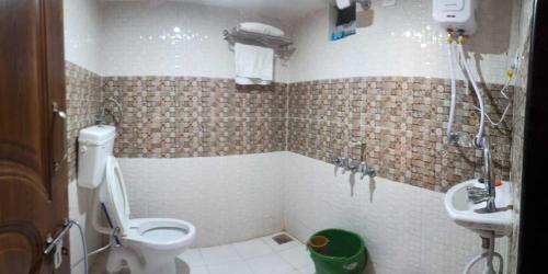 y baño con aseo y lavamanos. en Narmada NATH Homestay, en Rājpīpla