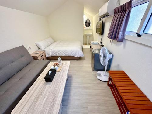 a small living room with a couch and a bed at Baluo Baluo in Sun Moon Lake