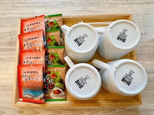 a tray with three cups and some snacks at Baluo Baluo in Sun Moon Lake