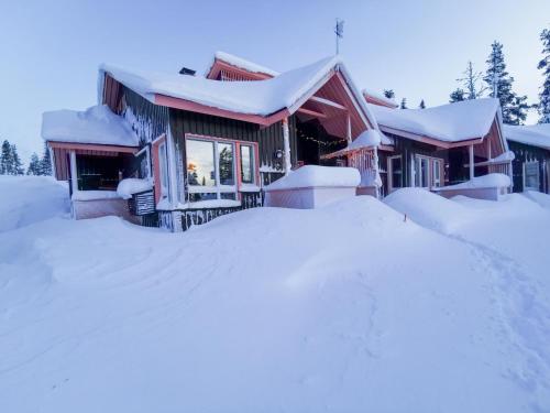 a house covered in snow with a pile of snow at Luttotupa in Saariselka